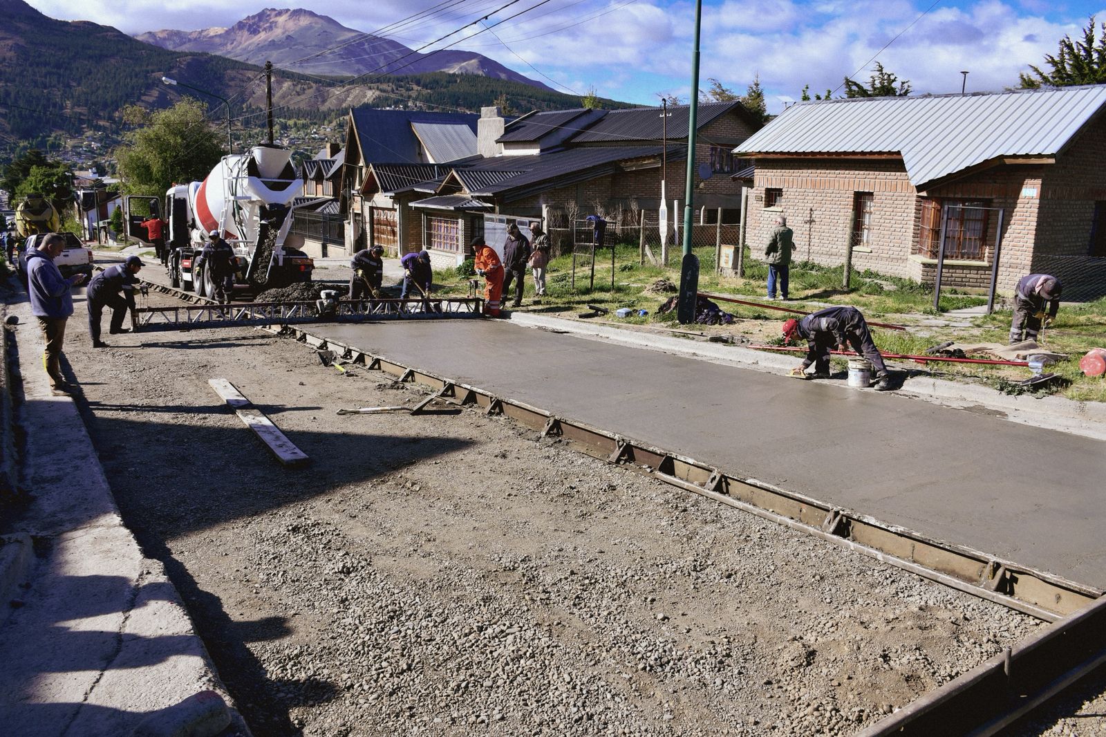 Operarios municipales realizan el hormigonado final en la calle 25 de Mayo, una de las 40 cuadras que el municipio de Esquel planea pavimentar este año.