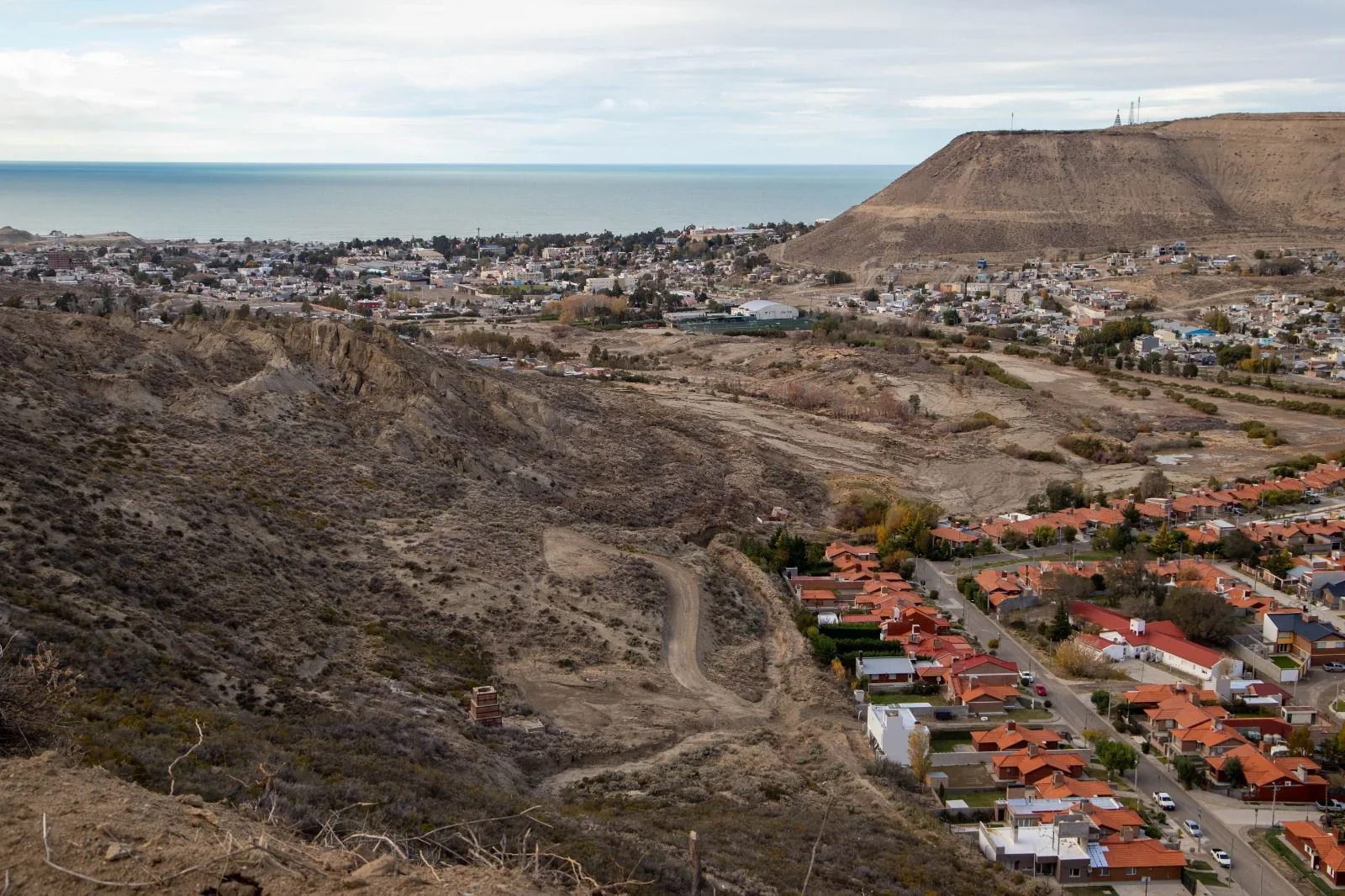 Vista panorámica del Cerro Hermitte y el barrio Médanos, mostrando el terreno árido y la zona urbana afectada.