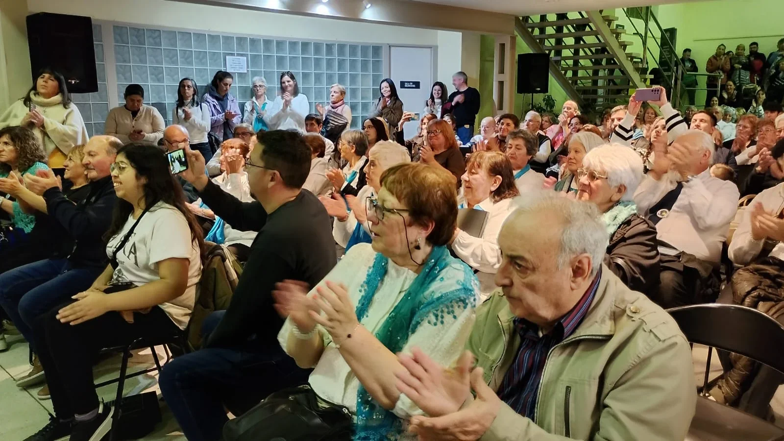 Público diverso aplaudiendo en un evento cultural del Municipio de Comodoro Rivadavia.