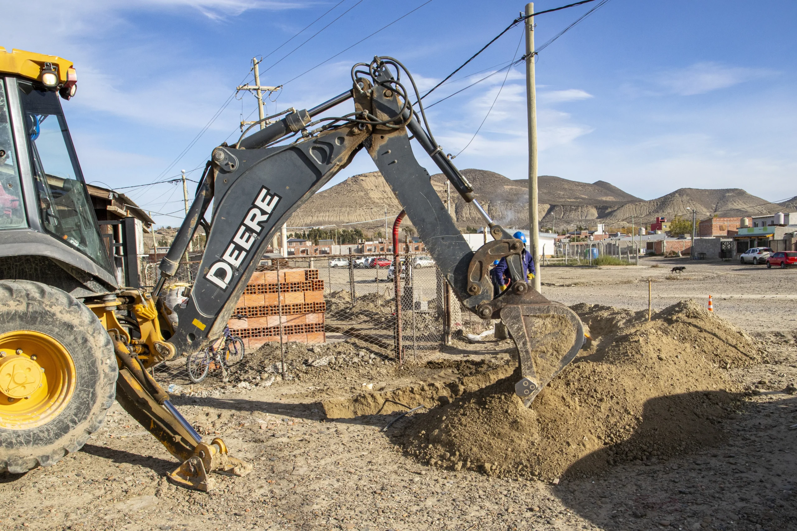 Retroexcavadora John Deere realizando excavaciones en el barrio René Favaloro, Comodoro Rivadavia.