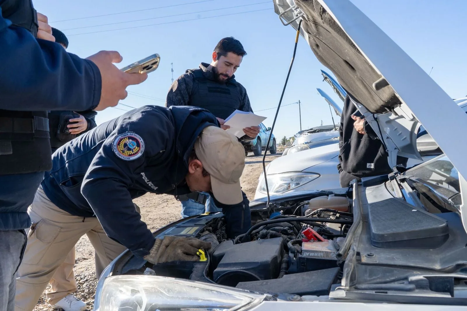 Personal de la Policía del Chubut inspecciona el motor de un vehículo durante los operativos en Km. 8, Comodoro Rivadavia.