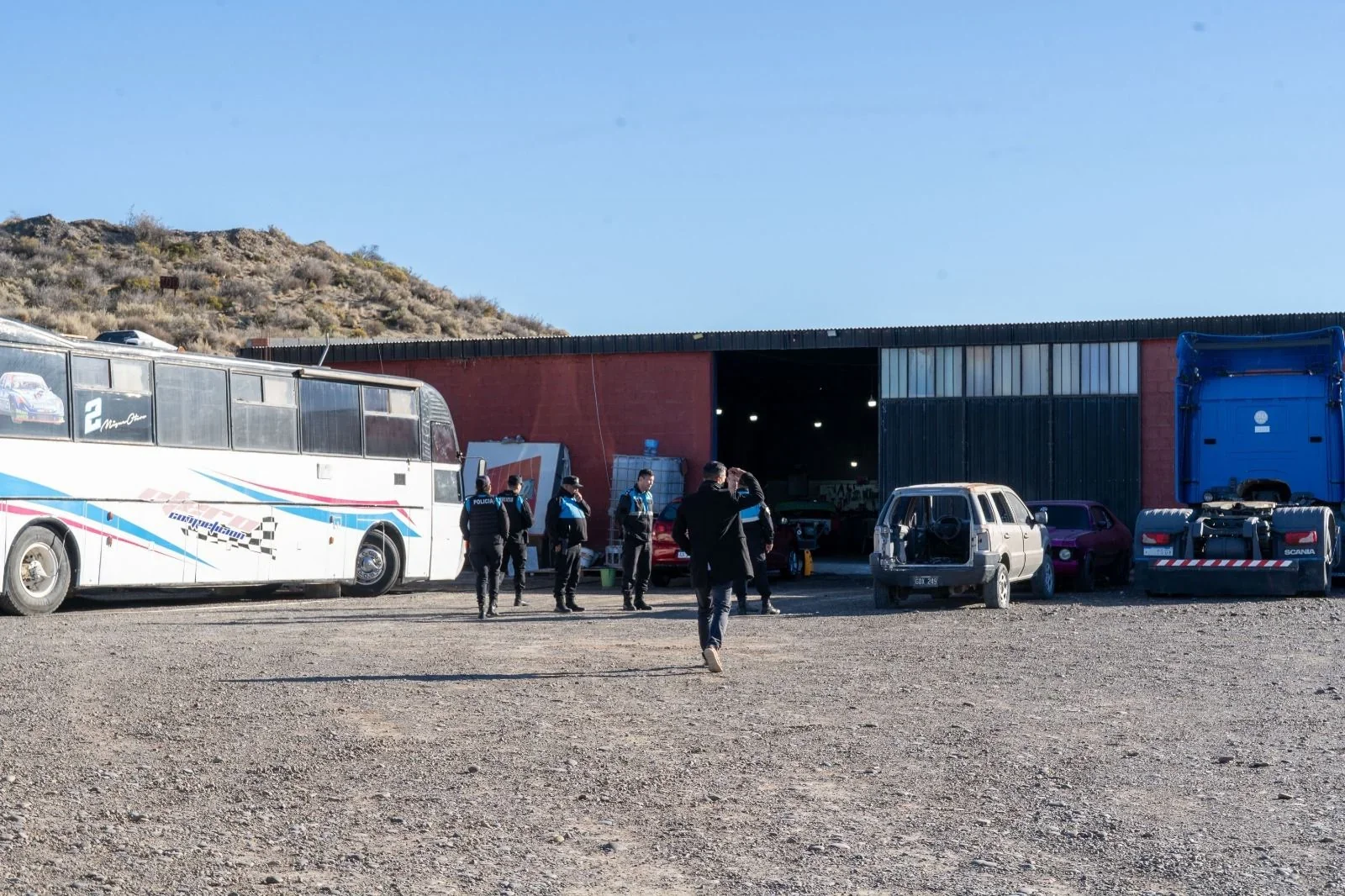 Personal policial y municipal frente a un taller en Km. 8 de Comodoro Rivadavia durante un operativo de clausura.