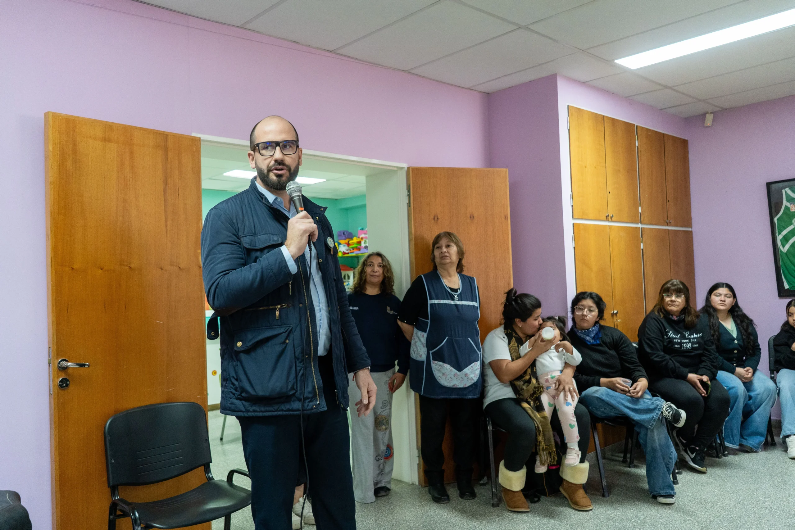 Hombre con micrófono hablando frente a un grupo de personas en el CPB Presidente Ortiz de Comodoro Rivadavia.