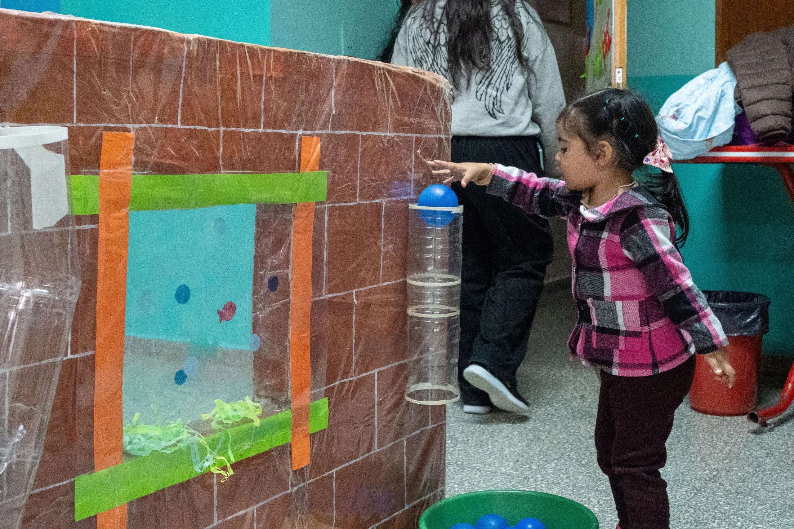 Niña participando en un juego recreativo con pelotas azules durante el 33° aniversario del CPB Presidente Ortiz.