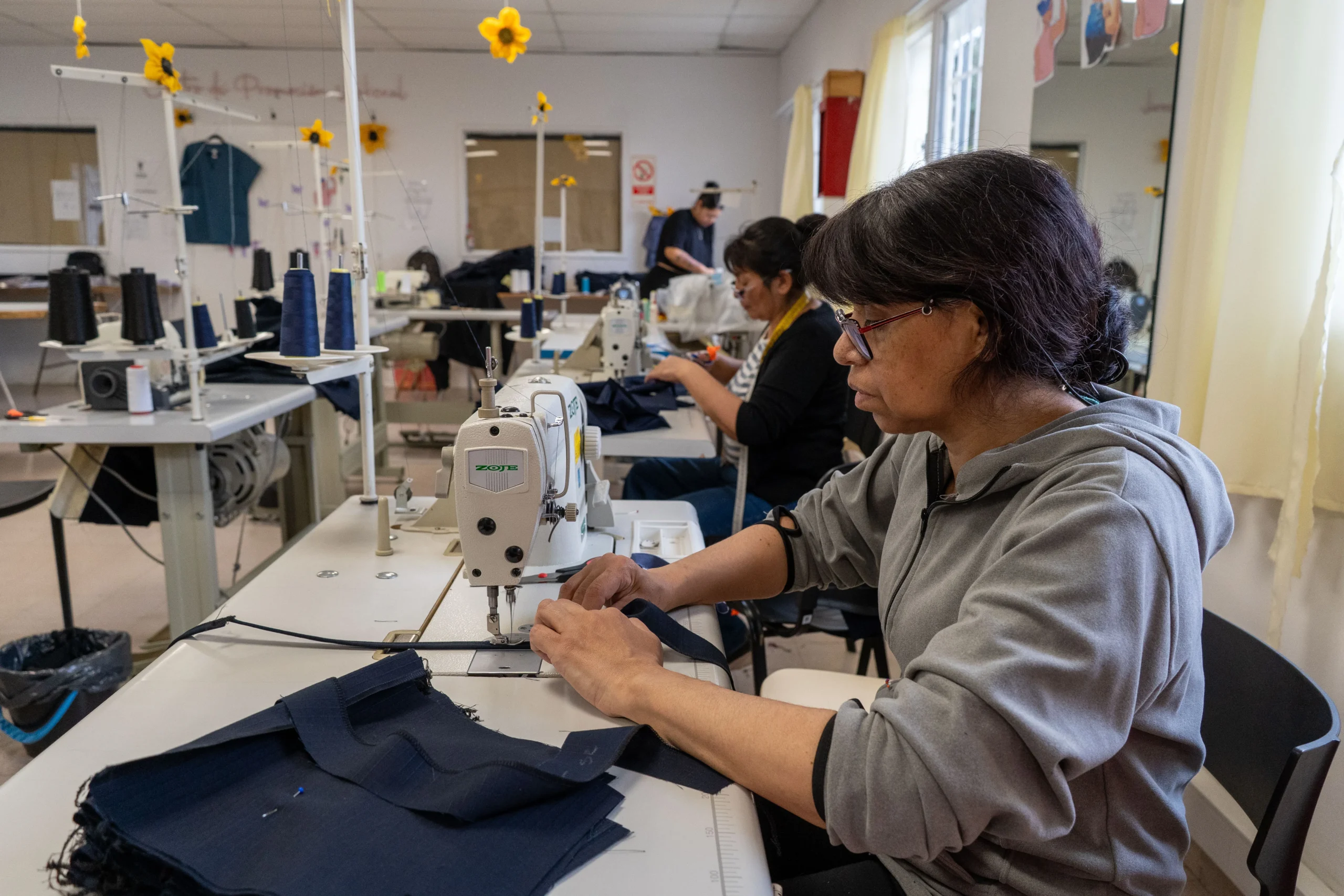 Mujeres confeccionando indumentaria municipal en las máquinas de coser del Centro de Promoción Laboral de Comodoro Rivadavia.