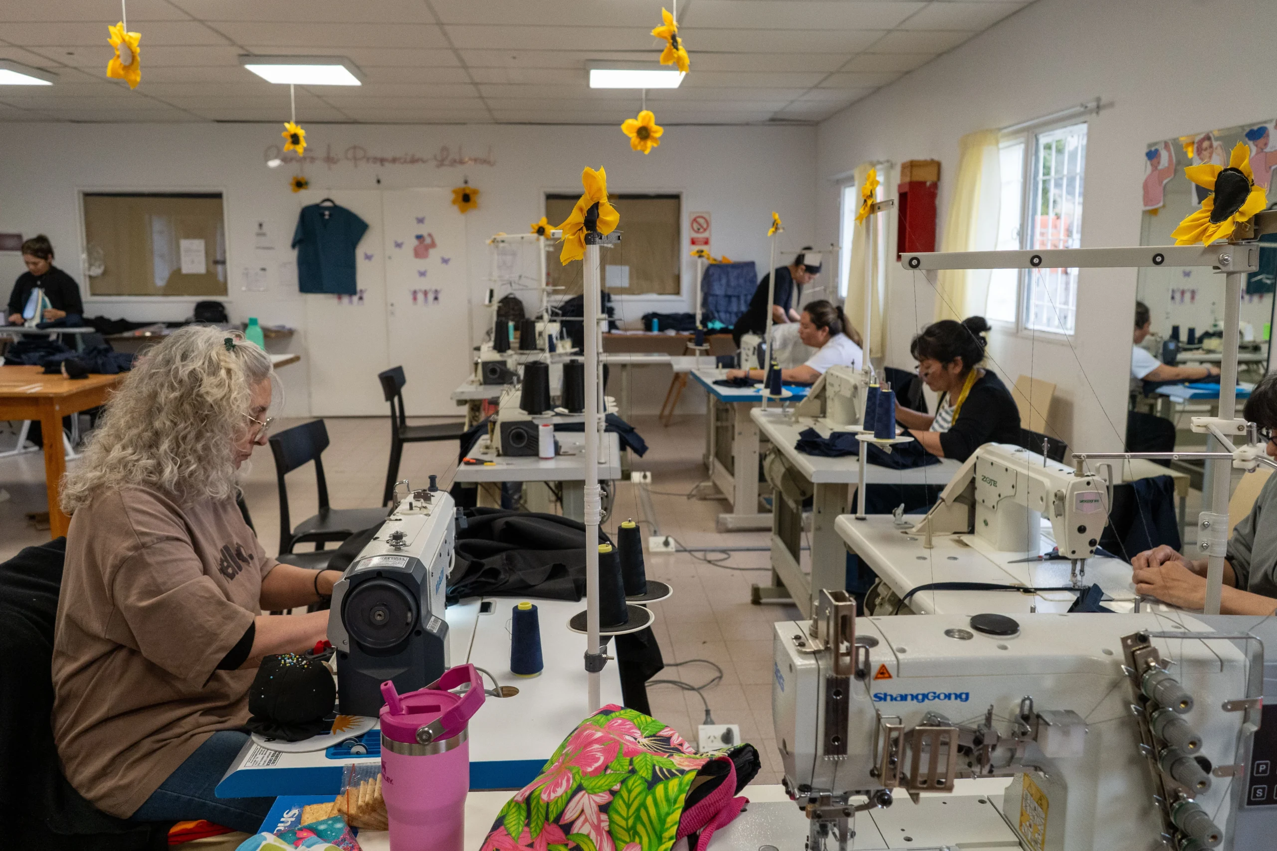 Mujeres confeccionando indumentaria municipal con máquinas de coser en el Centro de Promoción Laboral de Comodoro Rivadavia.