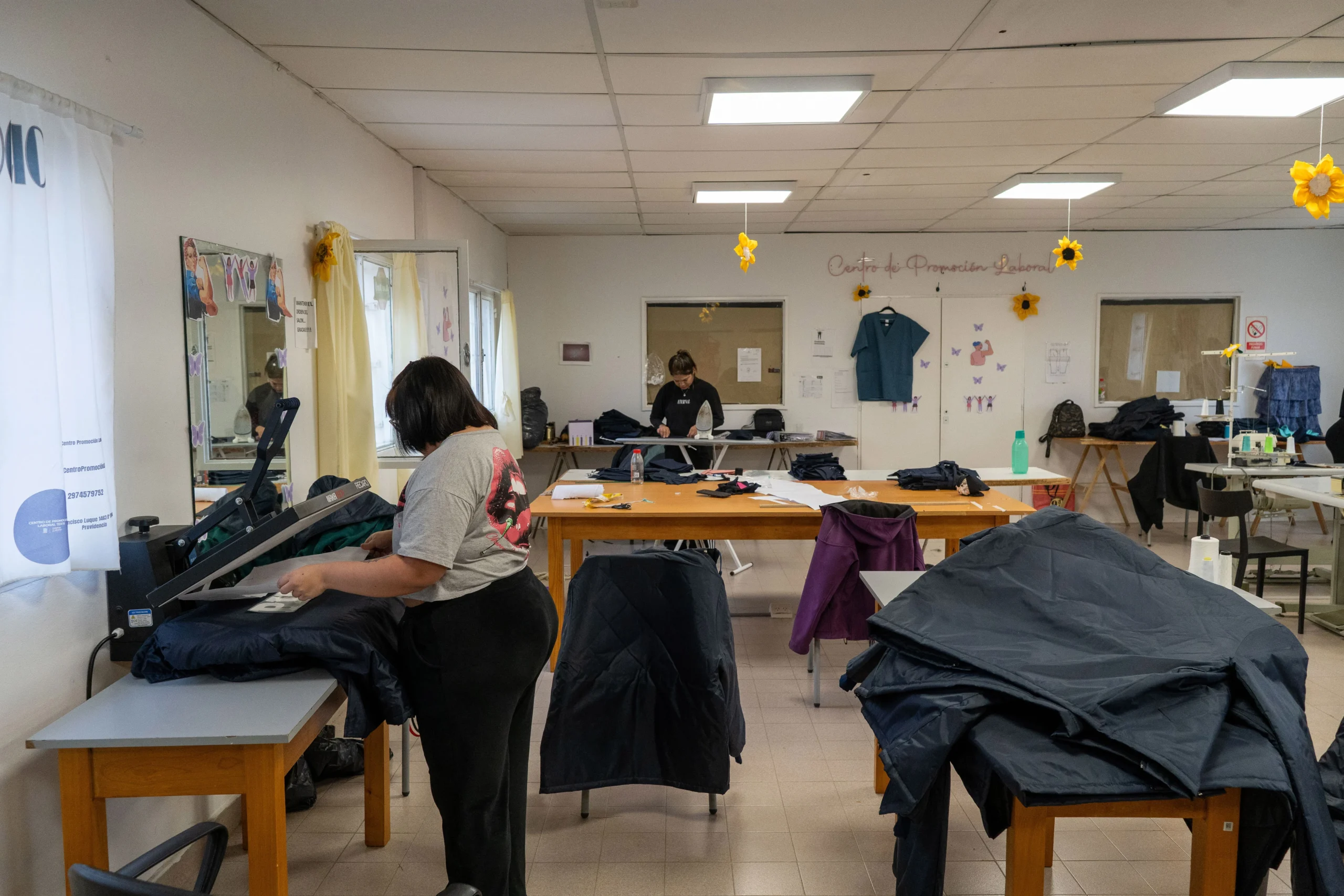 Mujeres trabajando en el Centro de Promoción Laboral de Comodoro Rivadavia confeccionando indumentaria municipal.