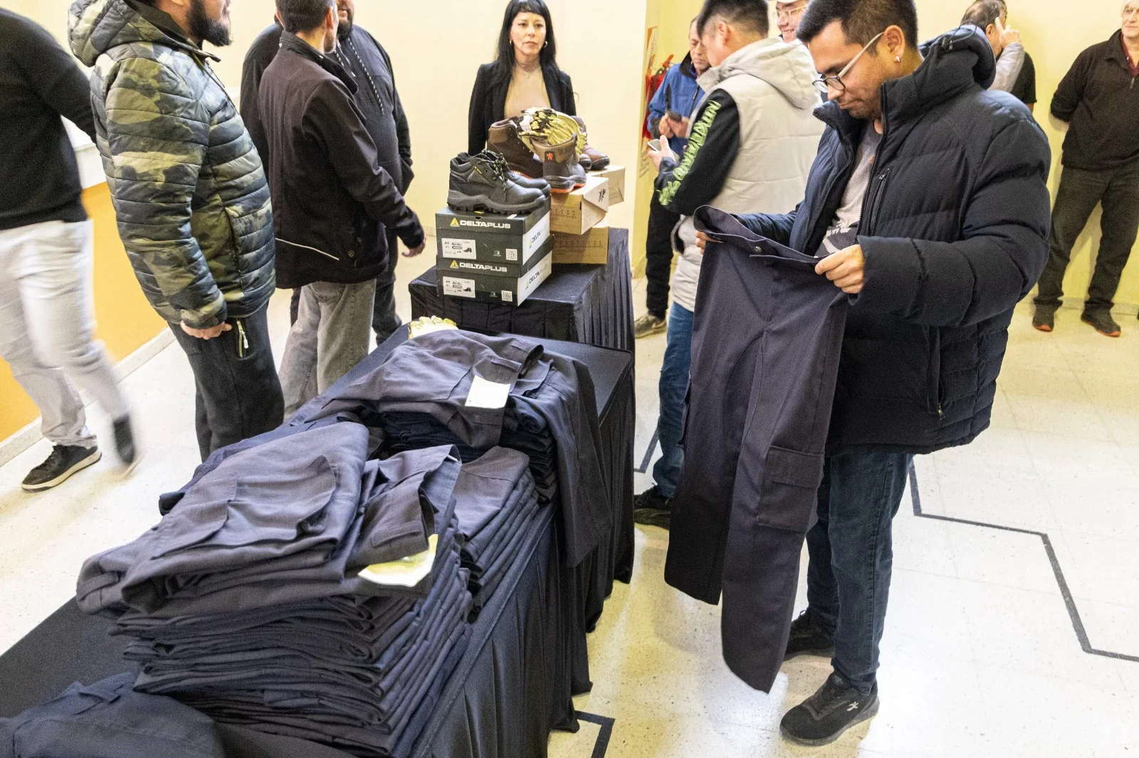 Trabajadores municipales revisan pantalones y calzado laboral confeccionados por el Centro de Promoción Laboral.