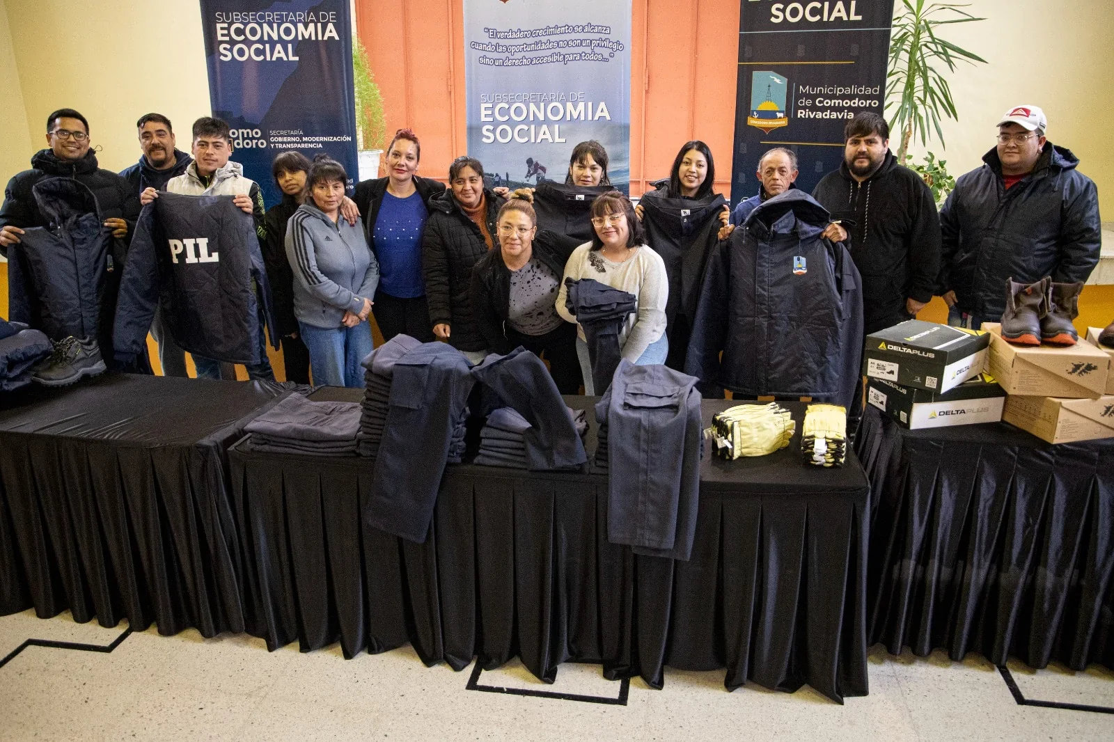 Grupo de personas posando junto a indumentaria laboral confeccionada por el CPL en Comodoro Rivadavia.