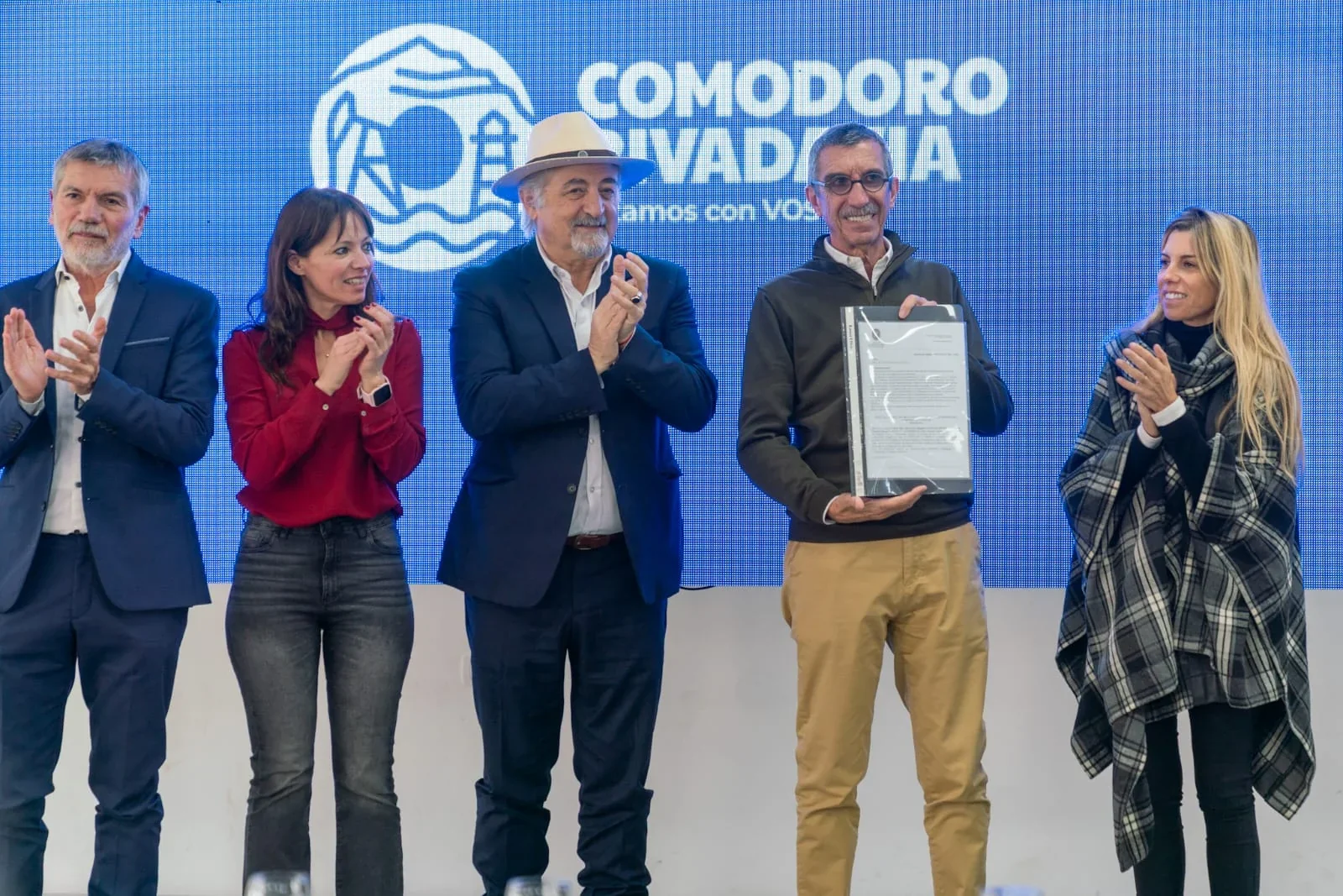 Autoridades municipales y universitarias posan junto a un documento en el lanzamiento de la diplomatura sobre autismo.