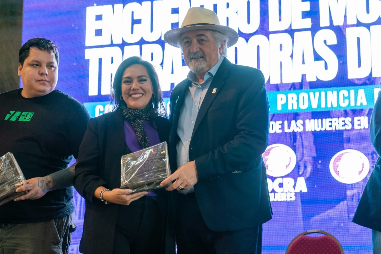 Othar Macharashvili entrega un reconocimiento a una mujer en el encuentro Mujeres Trabajadoras del Sur en Comodoro.
