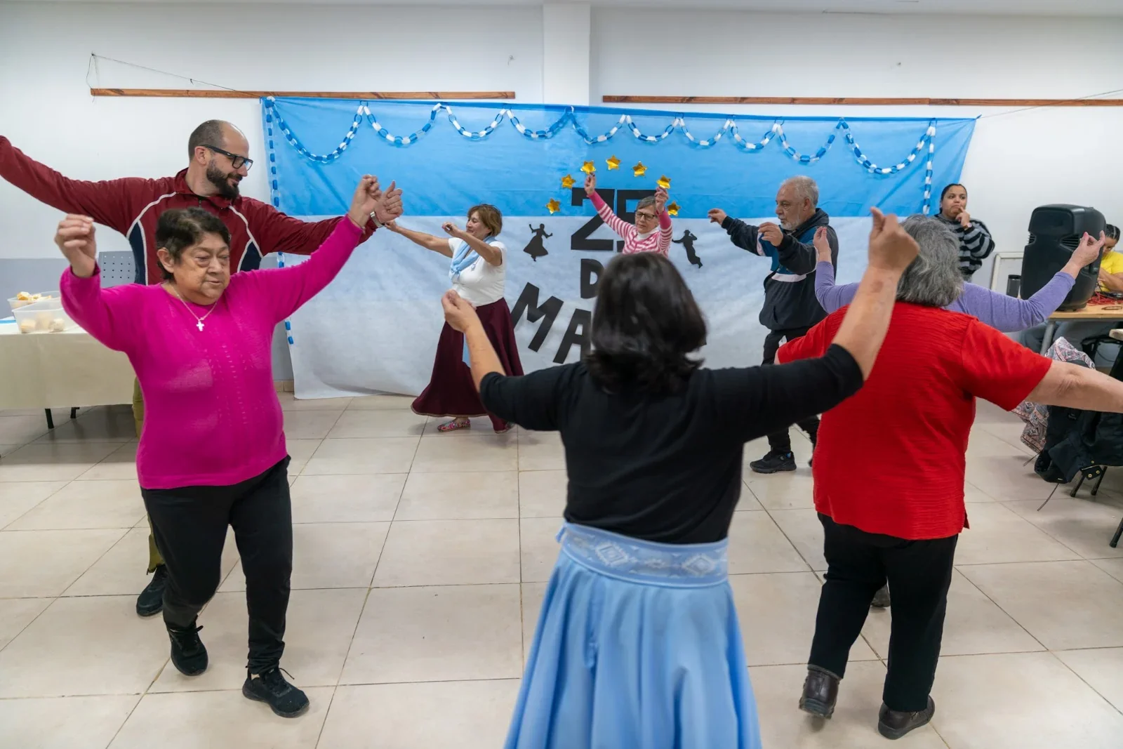 Adultos mayores de los grupos A.M.O. y Huellas de Abril bailando en la celebración del 25 de Mayo en Comodoro Rivadavia.