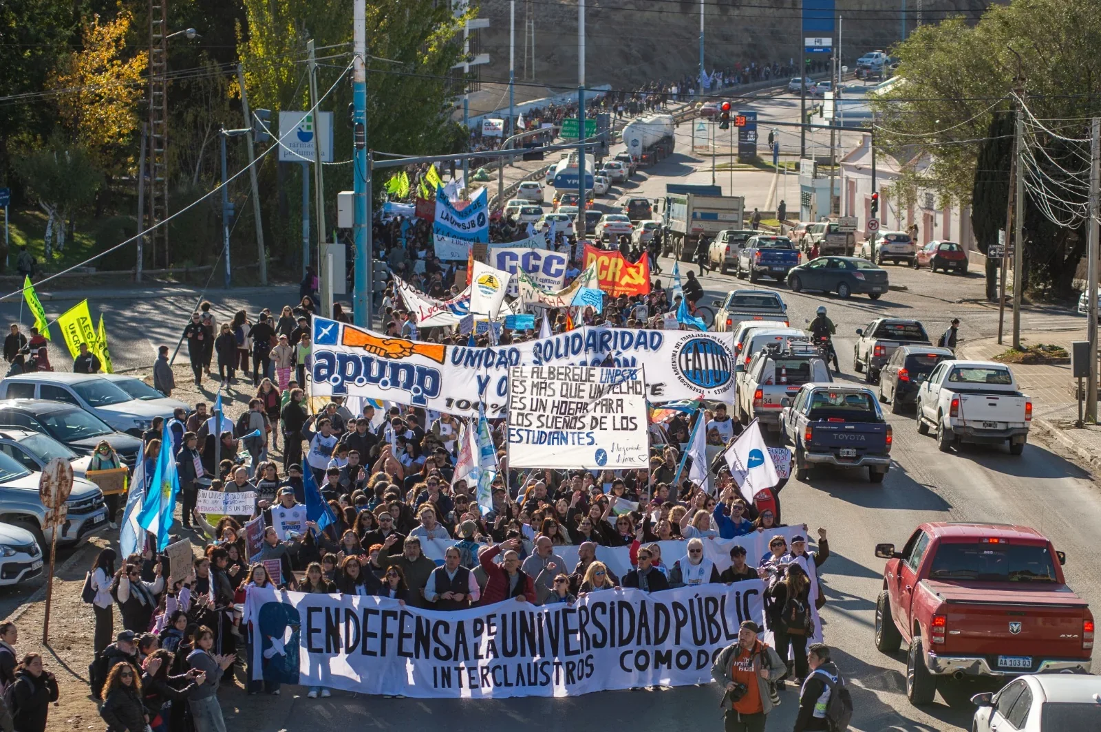 Multitudinaria Marcha Federal Universitaria en Comodoro Rivadavia con manifestantes portando banderas y pancartas.
