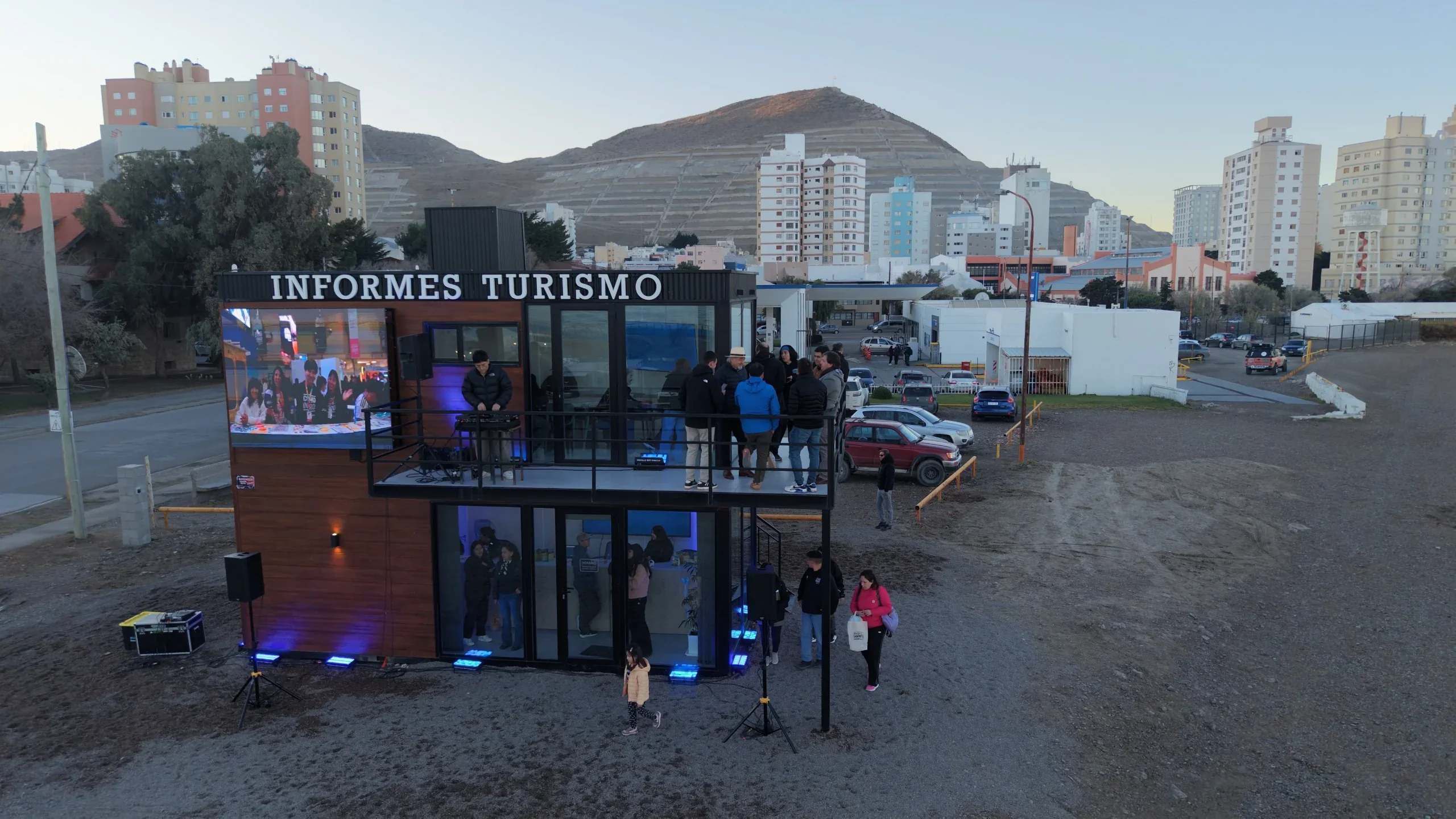 Inauguración del Centro de Información Turística en el Paseo Costero de Comodoro Rivadavia con personas y pantalla.
