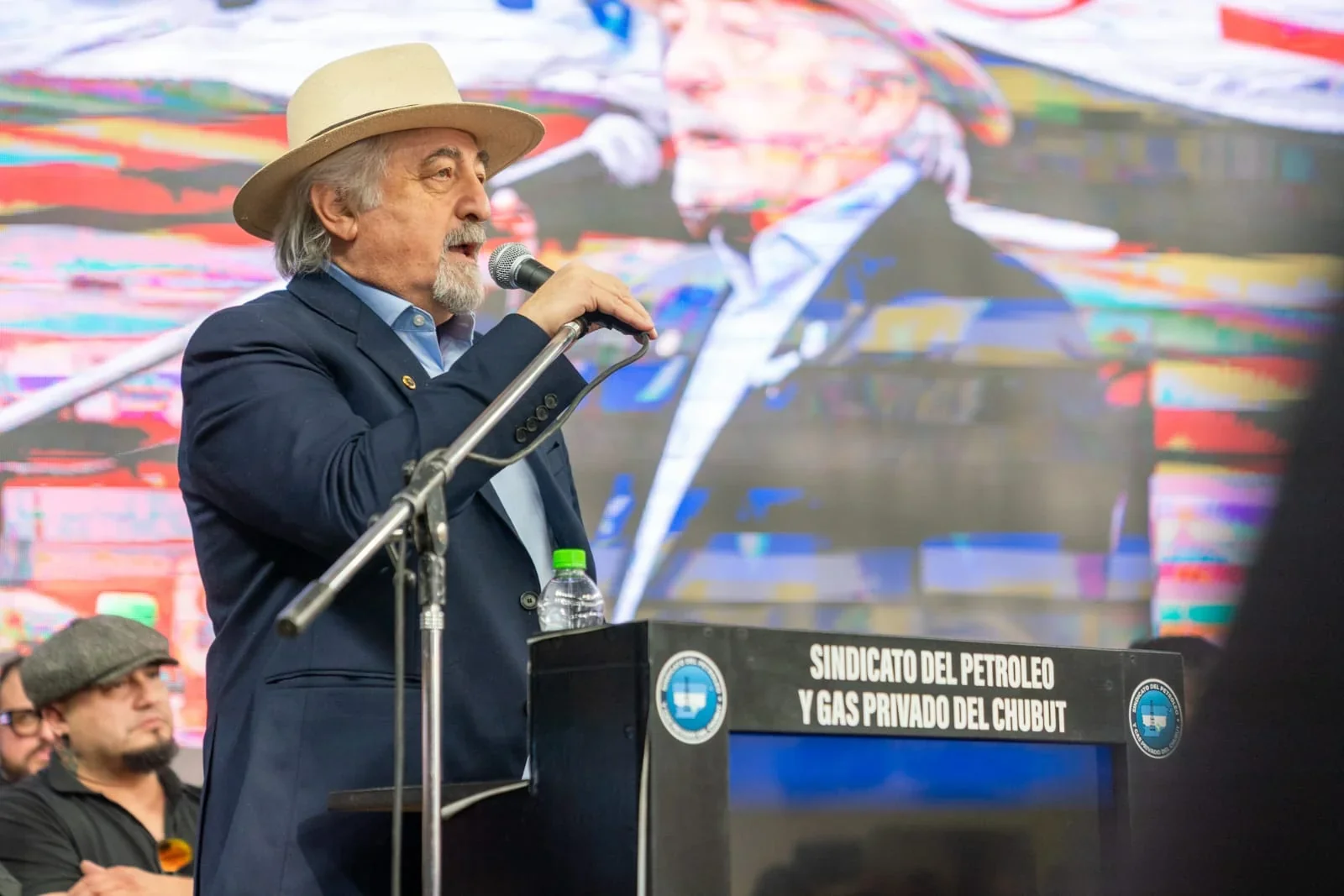Intendente Othar Macharashvili hablando frente a un podio del Sindicato del Petróleo y Gas Privado del Chubut.
