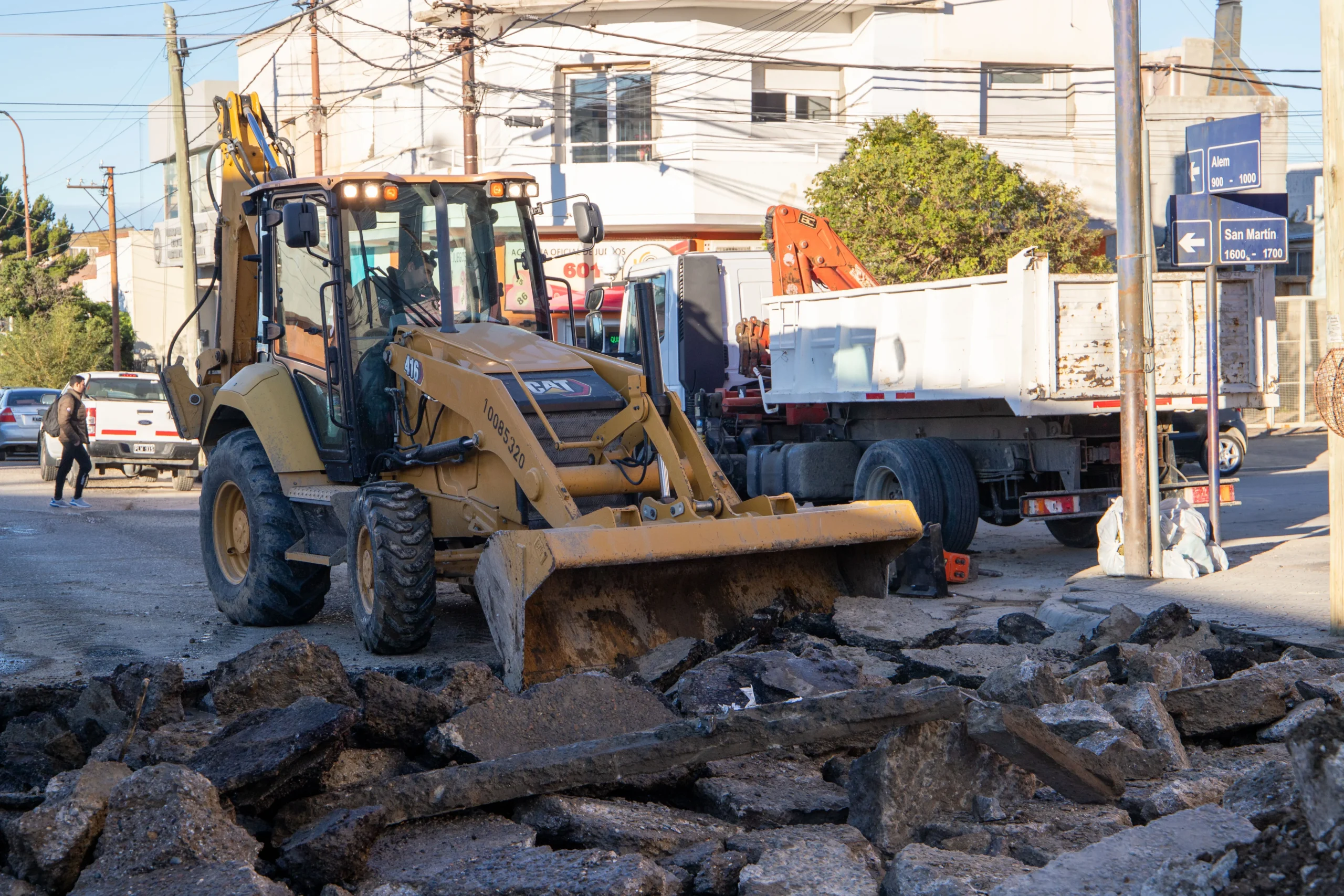 Maquinaria pesada Caterpillar removiendo escombros de asfalto en una calle de Comodoro Rivadavia.