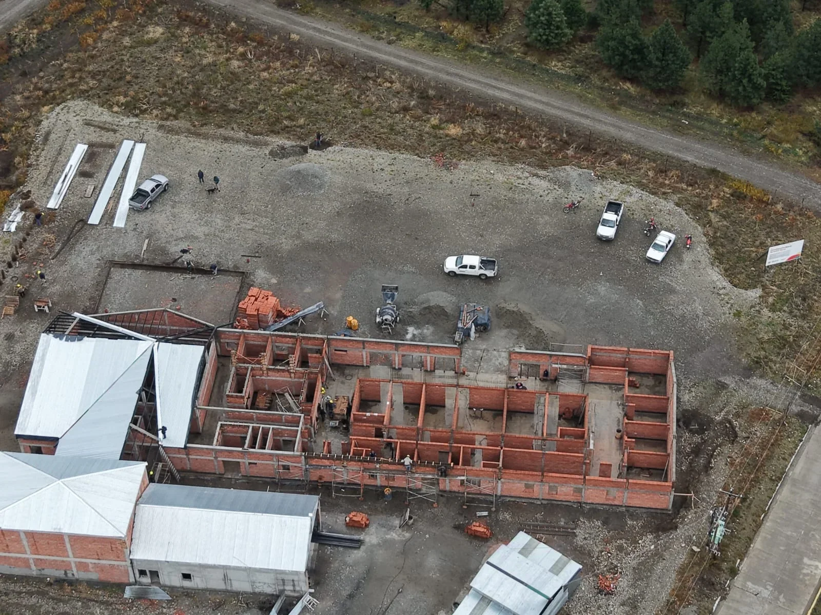 Vista aérea de la obra en construcción del nuevo Hospital Rural de Epuyén con muros de ladrillos y techos metálicos.