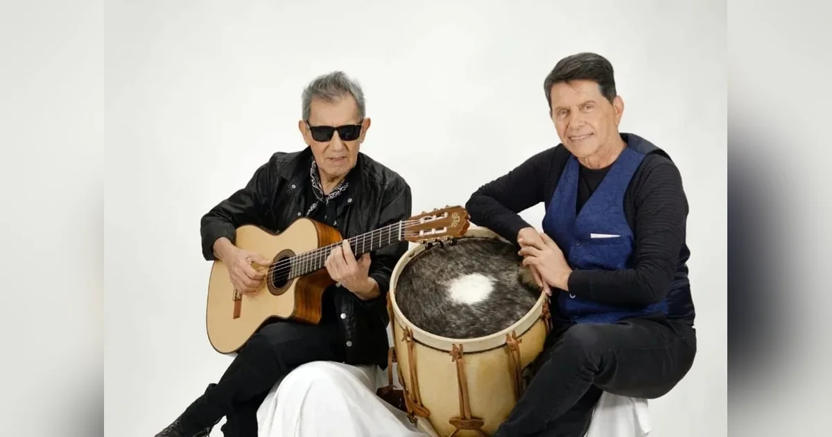 Puerto Madryn: El Pampero celebra su quinta Peña Patria con Cuti y Roberto Carabajal Cuti y Roberto Carabajal posando con una guitarra y un bombo legüero para la quinta Peña Patria de El Pampero.