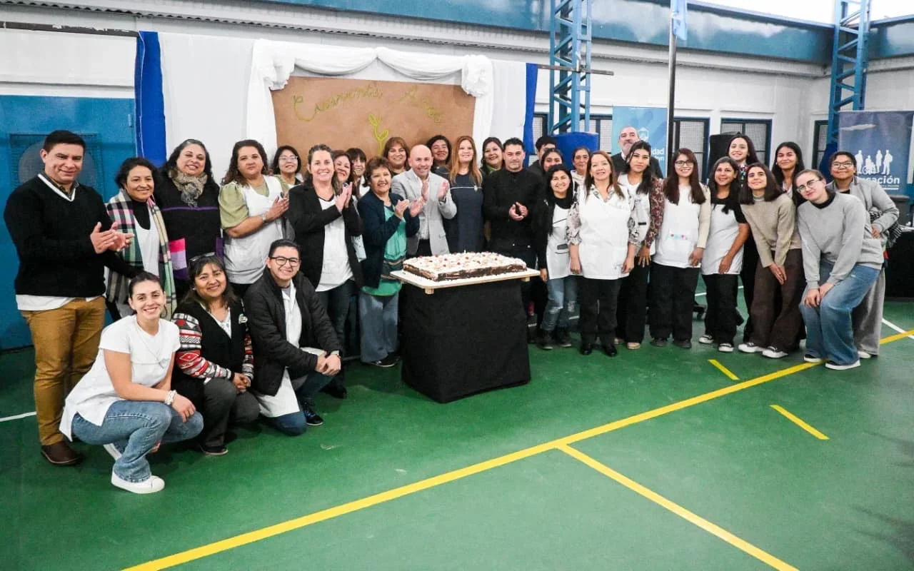 Gustavo Sastre y el personal de la Escuela Municipal N° 1 posan junto a una torta en el 40° aniversario institucional.