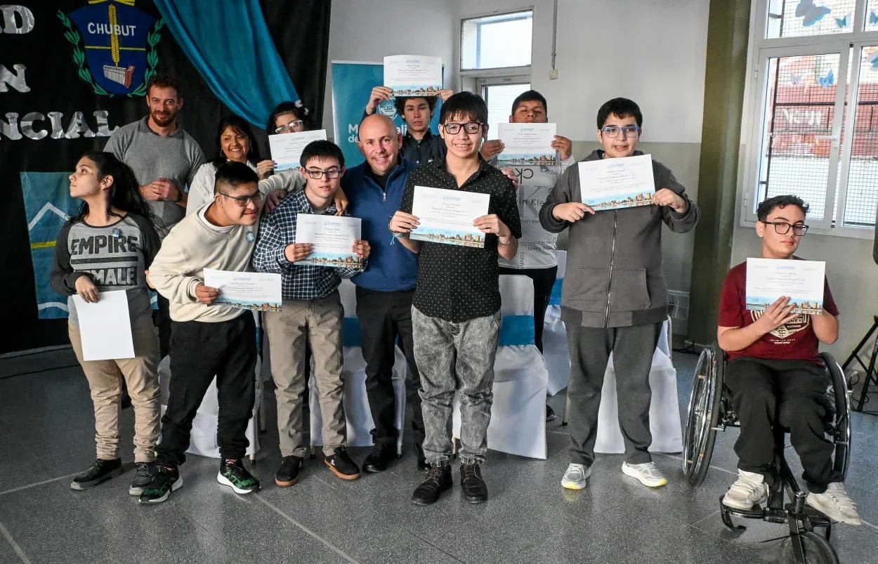 El intendente Gustavo Sastre junto a estudiantes de la Escuela N° 528 sosteniendo sus diplomas de lealtad a la Constitución.