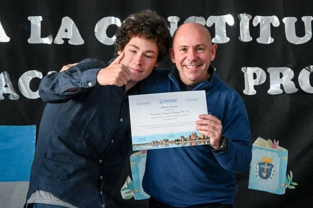 El intendente Gustavo Sastre y un alumno de la Escuela N° 528 sostienen un diploma de lealtad a la Constitución.