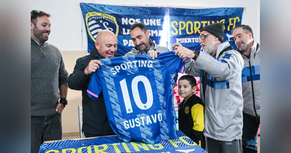 Puerto Madryn: Sastre entregó preadjudicación de tierras al Sporting Fútbol Club El intendente Gustavo Sastre y miembros del Sporting Fútbol Club sostienen una camiseta azul con el número 10.