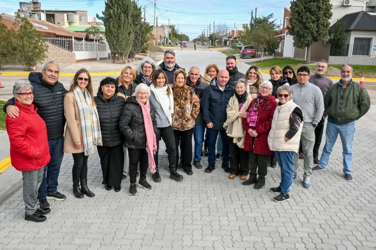 Intendente Gustavo Sastre y vecinos posan sobre la nueva pavimentación de adoquines en la calle Fournier, Puerto Madryn.