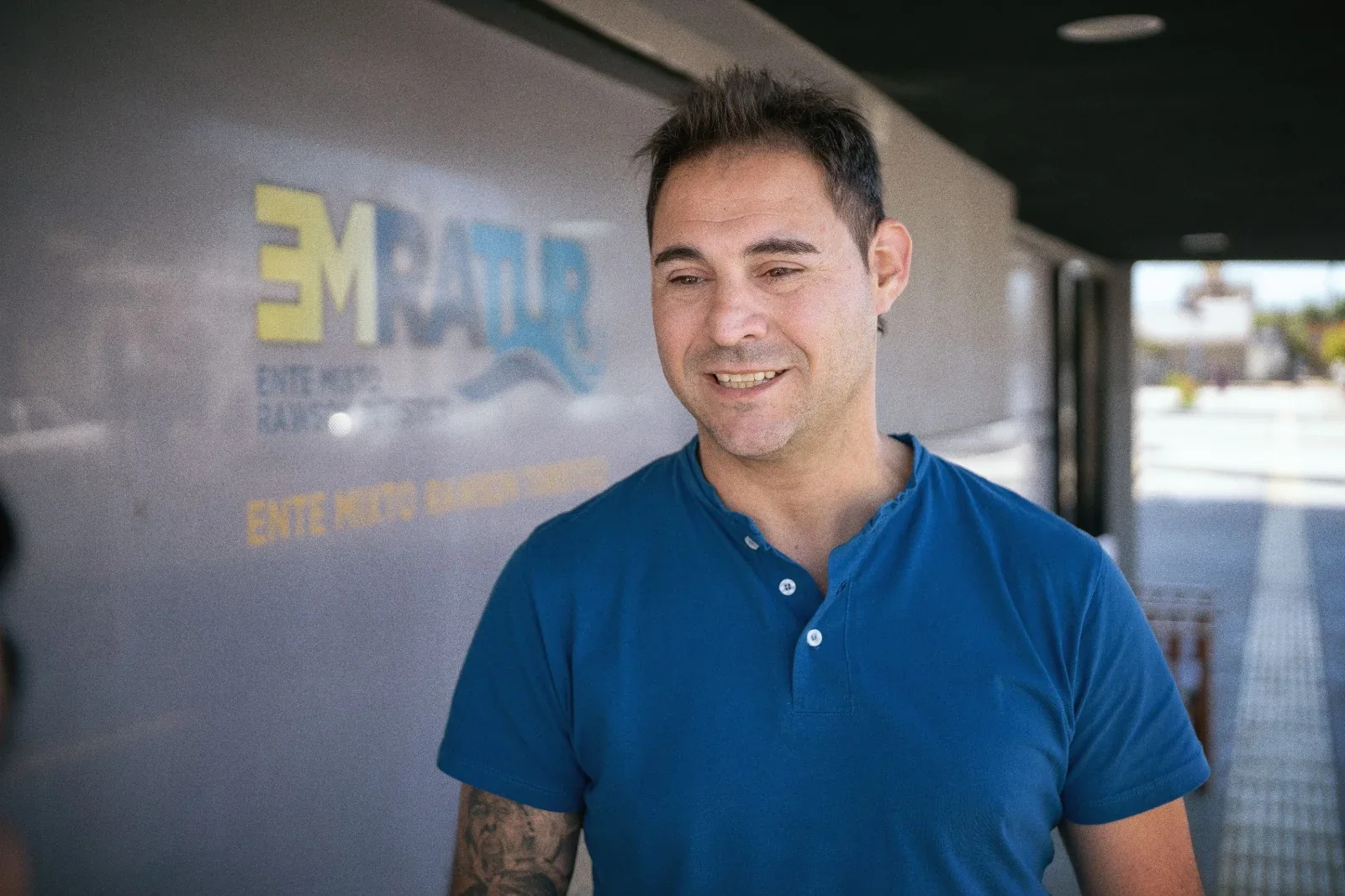 Federico Simboli, gerente de EMRaTur, posando frente al logo del Ente Mixto Rawson Turístico.