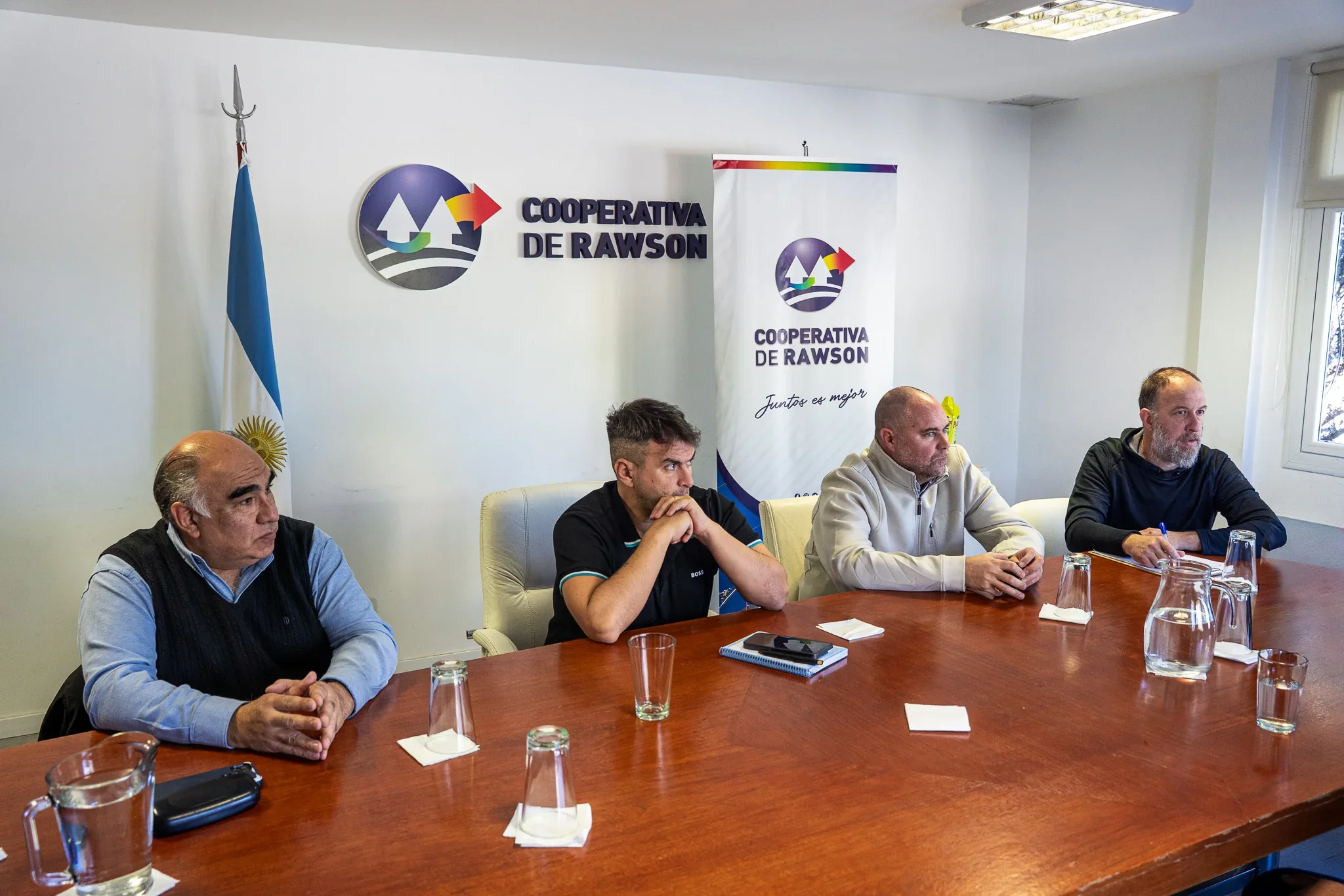 Reunión de trabajo entre representantes de la Cooperativa de Rawson y el Hospital Santa Teresita en una oficina.
