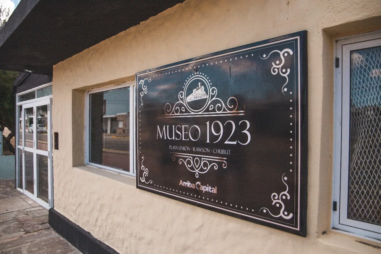Cartel negro con letras blancas del Museo 1923 en Playa Unión, Rawson, parte del circuito histórico cultural.