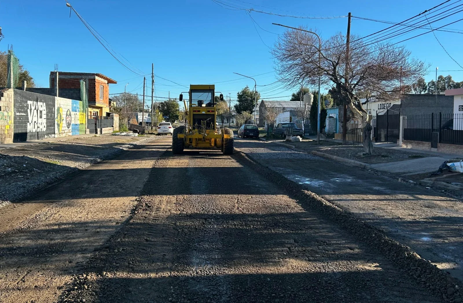 Motoniveladora amarilla realizando trabajos de repaso de una calle de tierra en el barrio Río Chubut, Rawson.