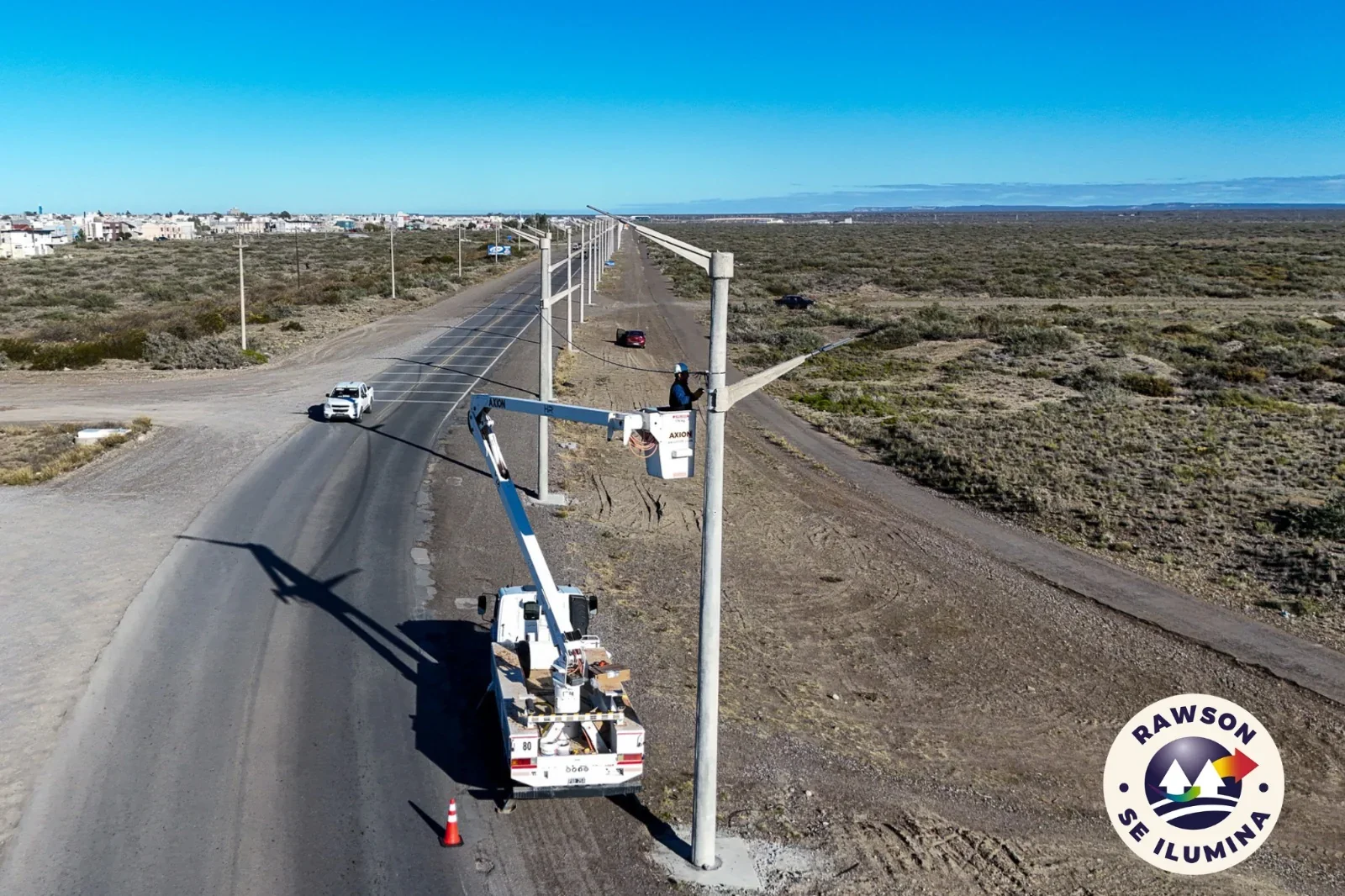 Operario de la Cooperativa de Servicios Públicos instalando luminarias LED en la Av. Marcelino González, Rawson.