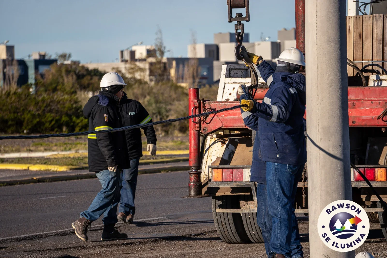 Trabajadores de la Cooperativa realizan el tendido eléctrico en la avenida Marcelino González de Playa Unión, Rawson.