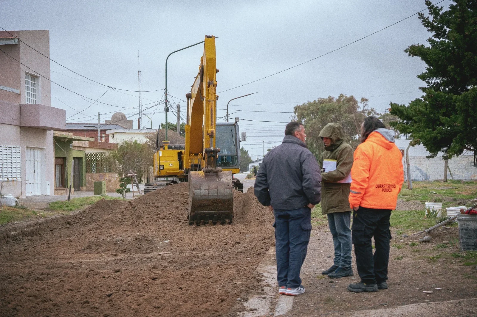 Maquinaria pesada y personal municipal realizando movimiento de suelo en calle Rivadavia, Playa Unión, Rawson.