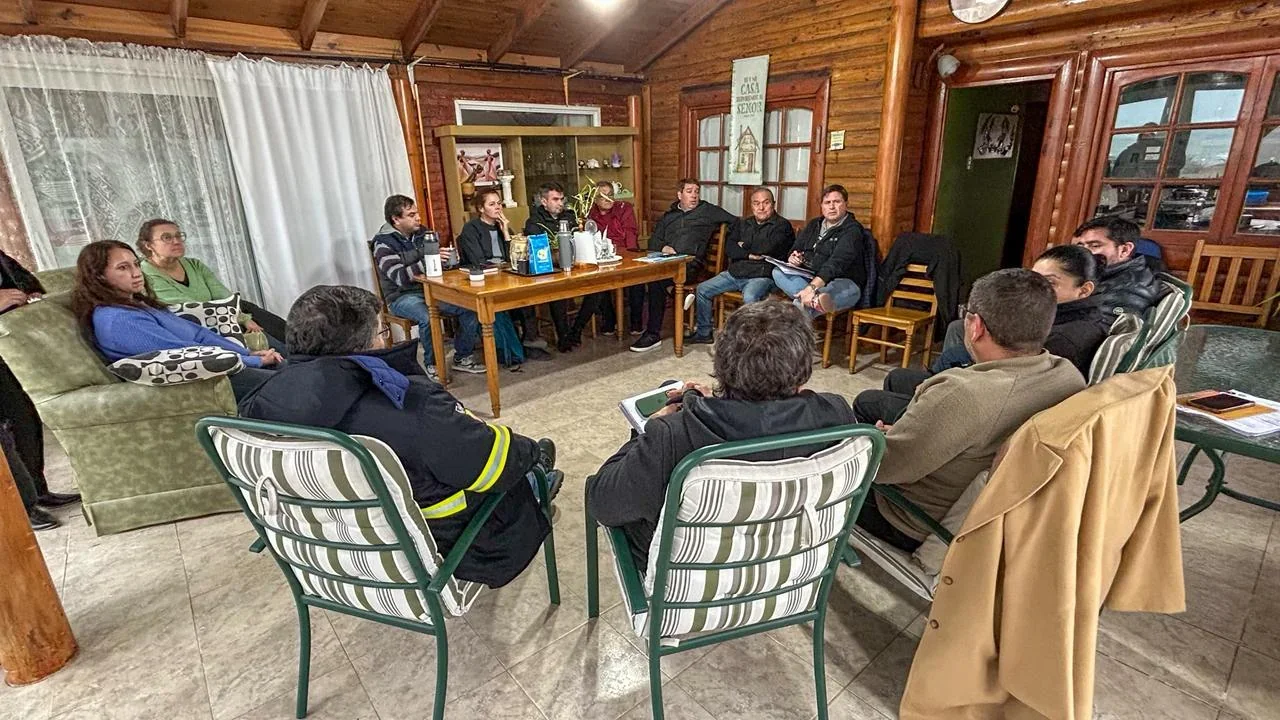 El intendente Damián Biss y funcionarios se reúnen con la Comisión Vecinal del Complejo Magagna en un salón rústico.