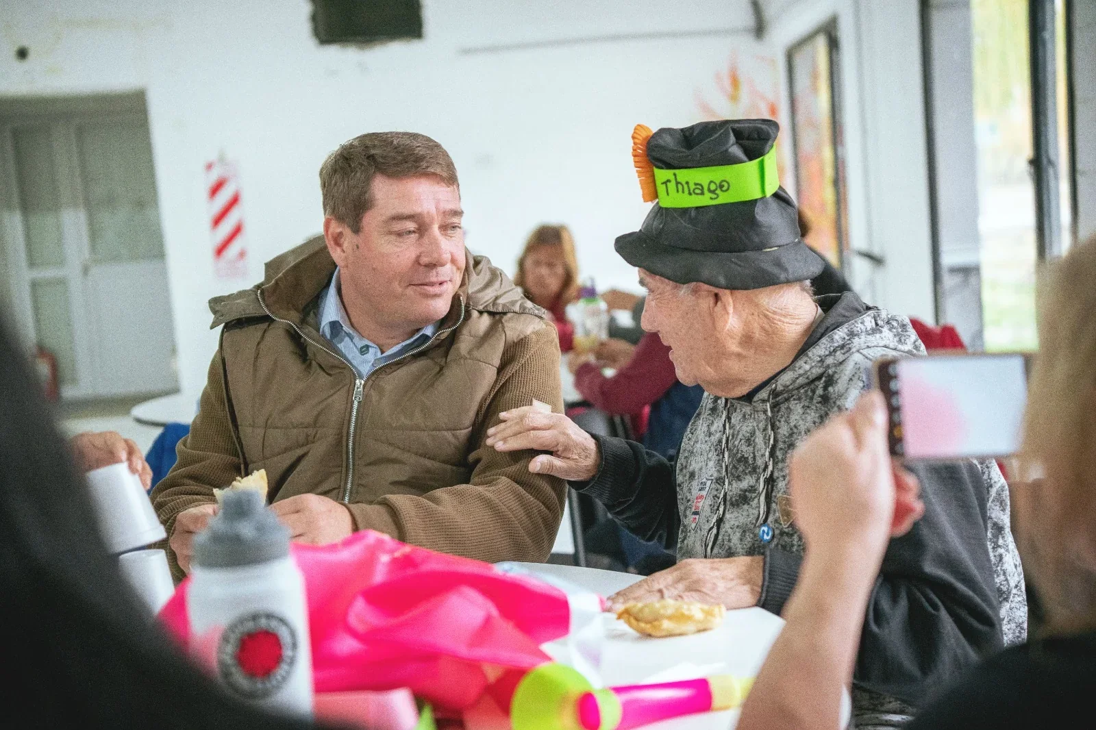 El intendente Damián Biss conversa con un adulto mayor durante la Colonia Recreativa de Personas Mayores en Rawson.