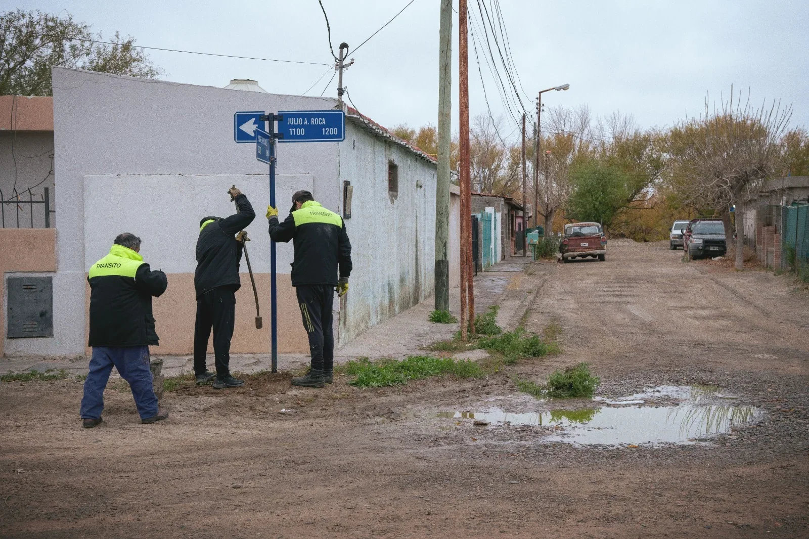 Operarios municipales de tránsito realizando trabajos de mantenimiento en una calle del barrio General Valle, Rawson.