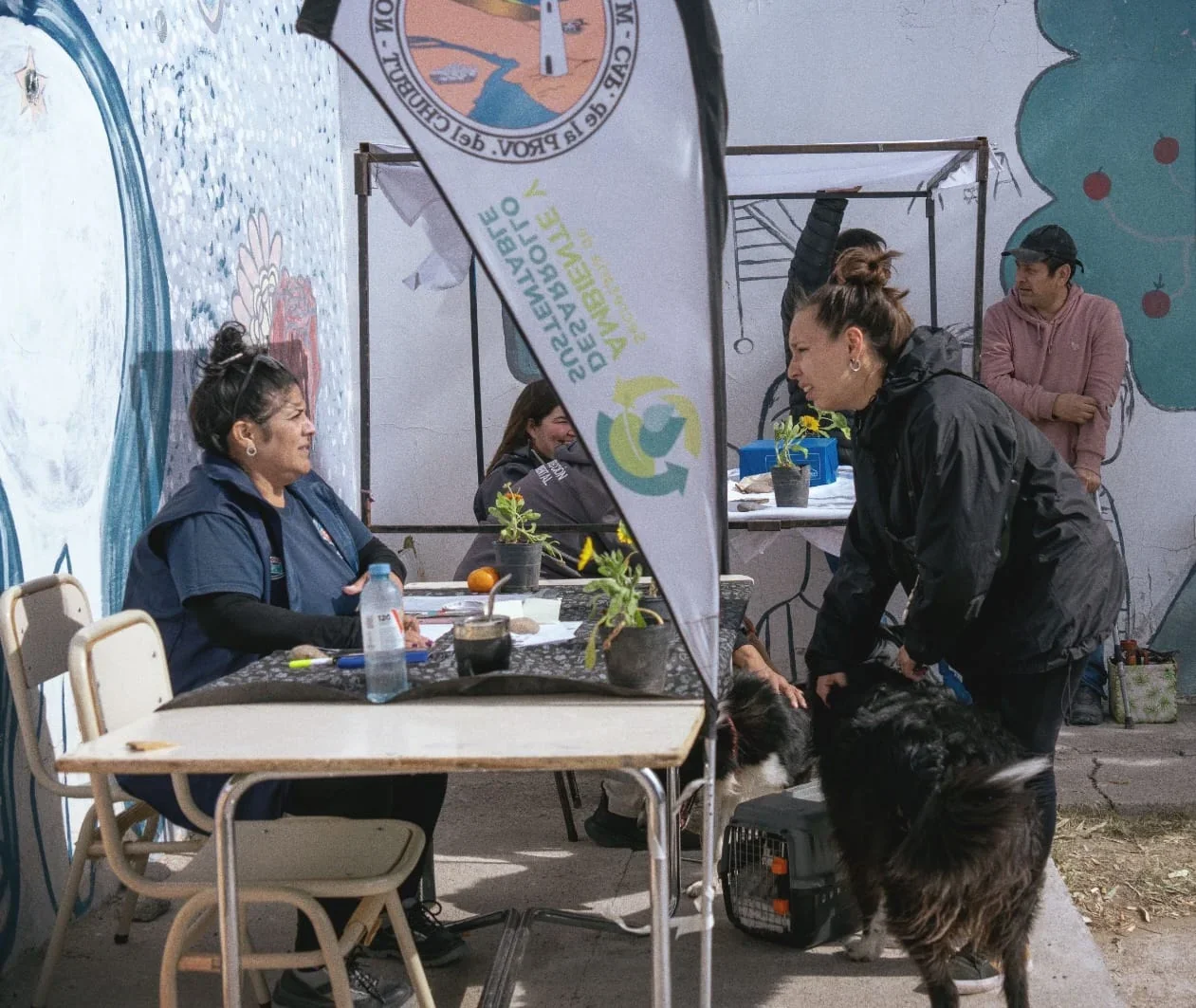 Personal municipal atiende a una vecina con sus perros en el operativo Ambiente va a tu barrio en Rawson.