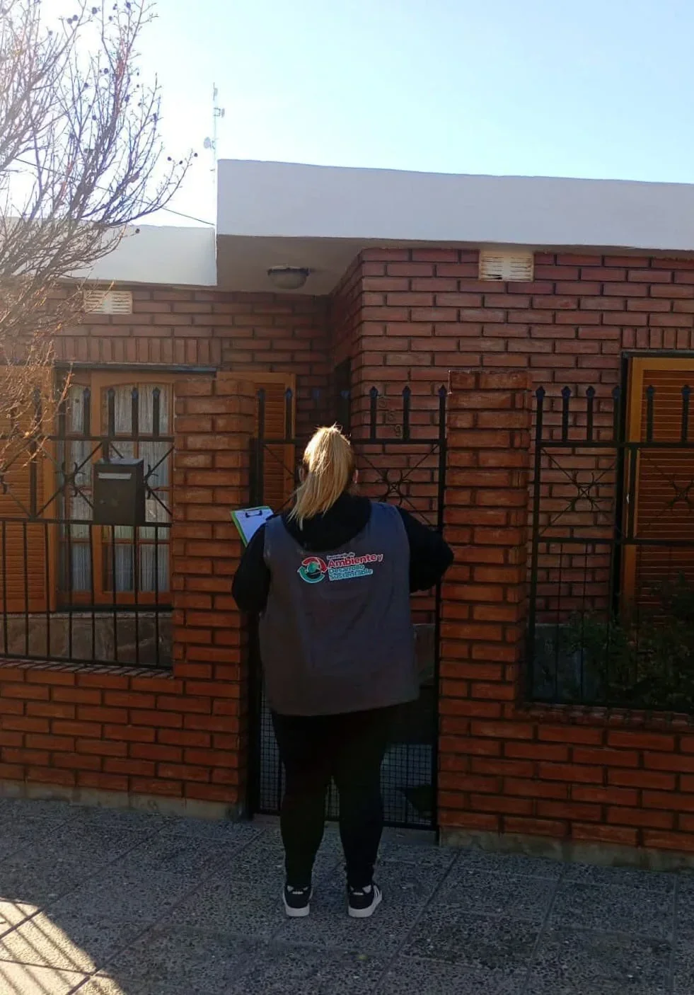 Personal de Veterinaria de Rawson con chaleco institucional realizando el censo animal en una casa del barrio General Valle.