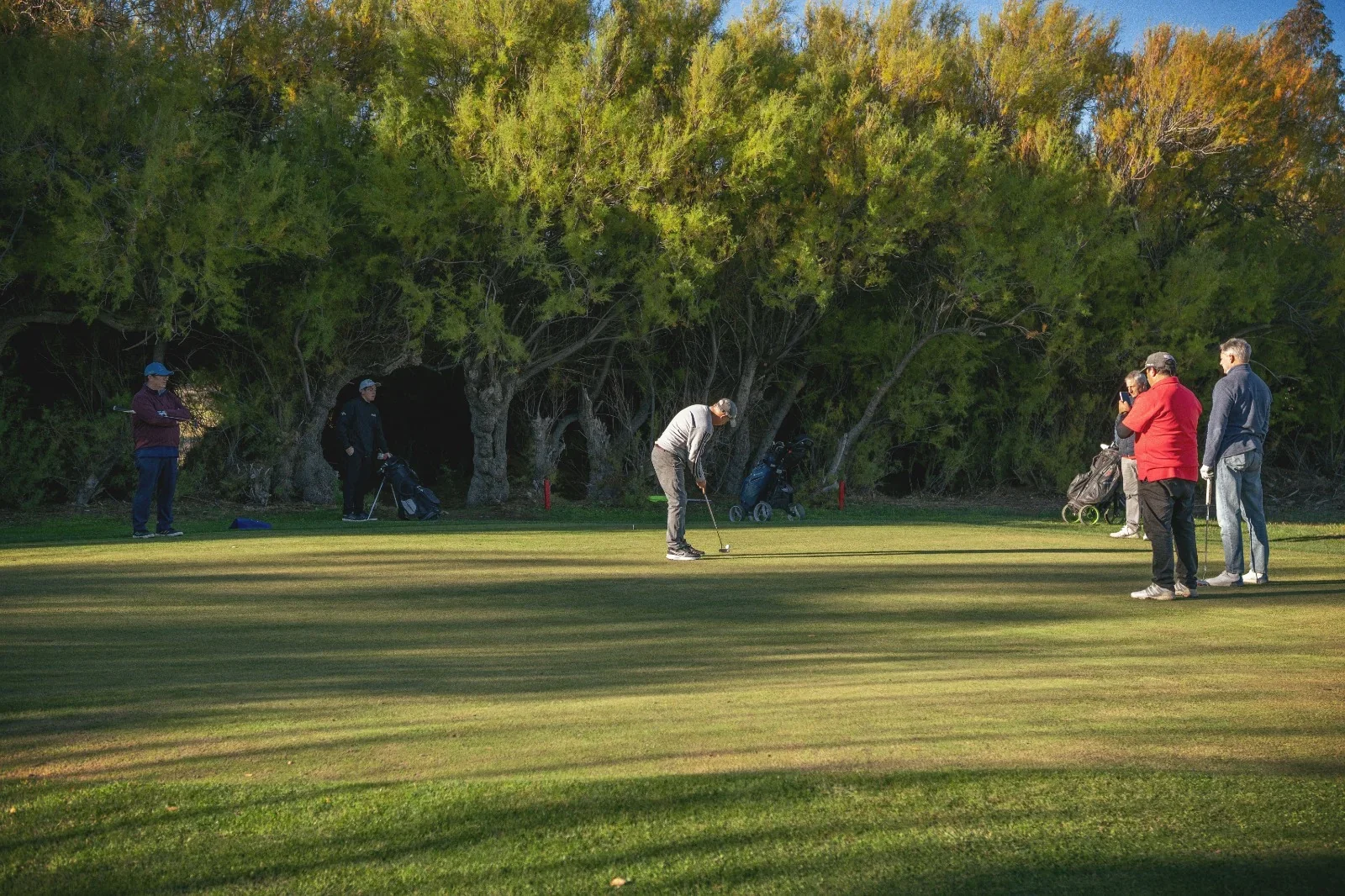 Golfista realizando un putt en el campo de Tamariscos Golf Club durante el torneo por su décimo aniversario en Rawson.