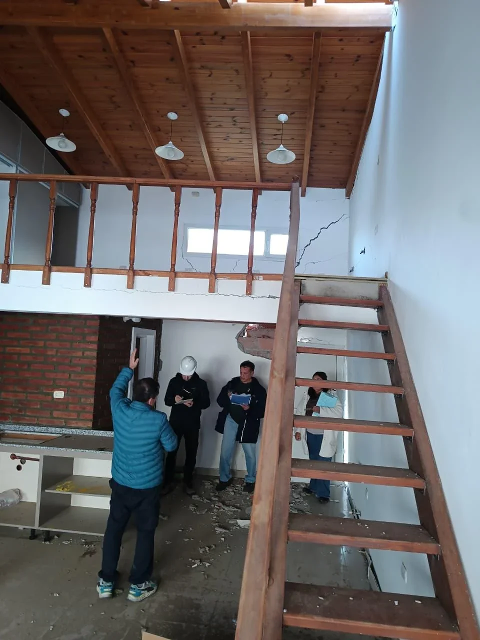 Personal municipal y un ingeniero realizan un peritaje estructural en una vivienda dañada de Comodoro Rivadavia.
