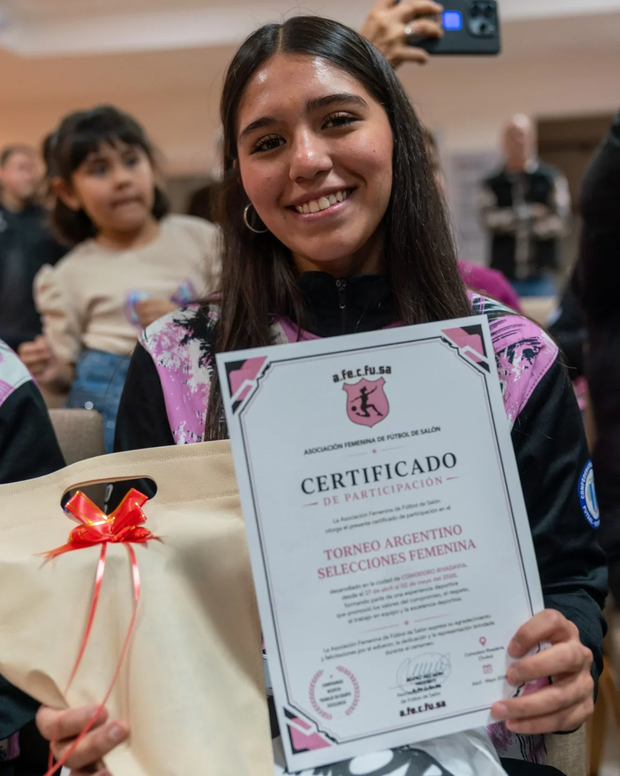 Una jugadora de futsal sostiene un certificado de participación del Torneo Argentino Selecciones Femenina en Comodoro.