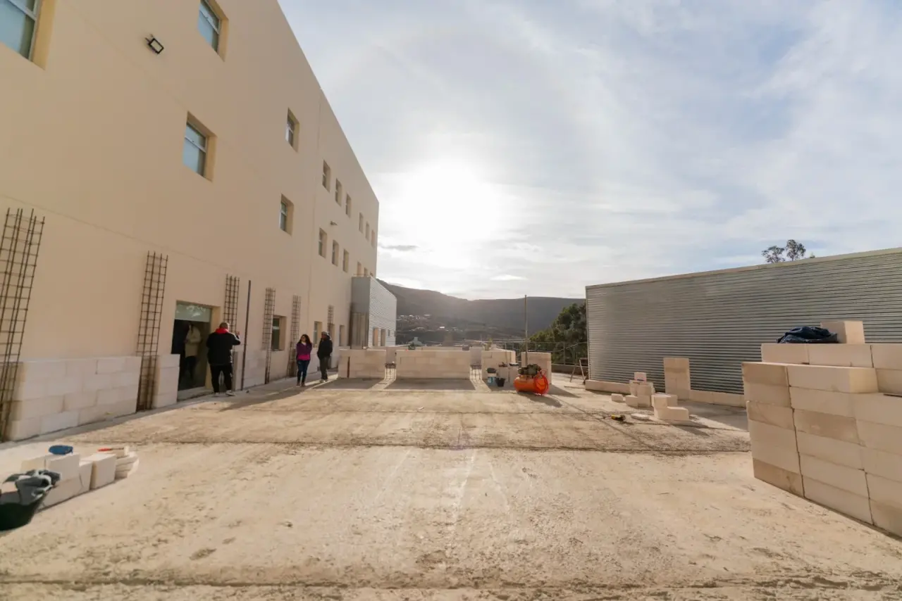 Othar Macharashvili y acompañantes recorren las obras de construcción en un espacio comunitario de Comodoro Rivadavia.