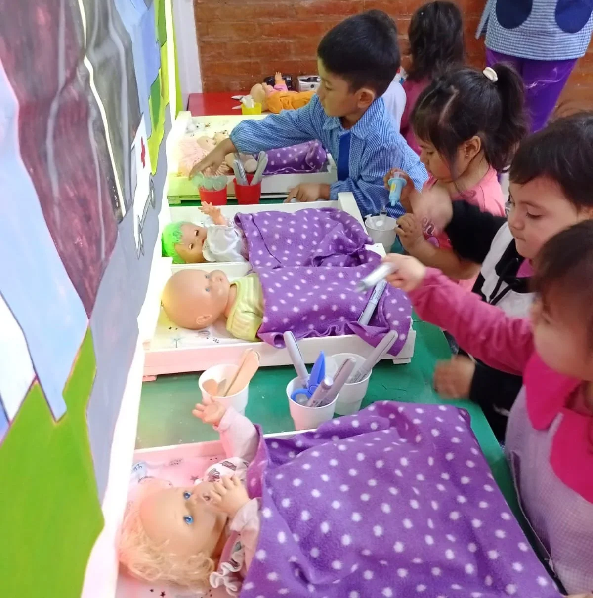 Niños y niñas del Centro de Primera Infancia Laurita Vicuña jugando con muñecos en una actividad pedagógica.