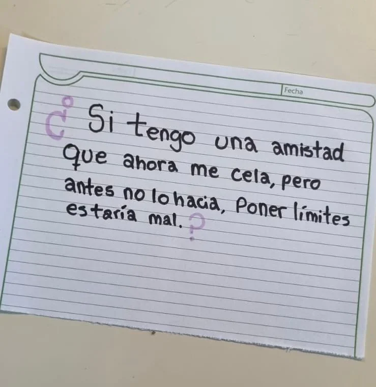 Nota escrita a mano sobre una hoja de cuaderno con una pregunta sobre poner límites en una amistad con celos.