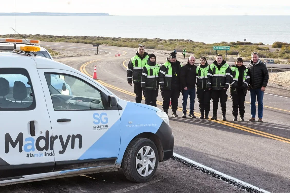 Grupo de personas y personal municipal junto a un vehículo de Puerto Madryn en el nuevo asfalto hacia Playa Las Canteras.