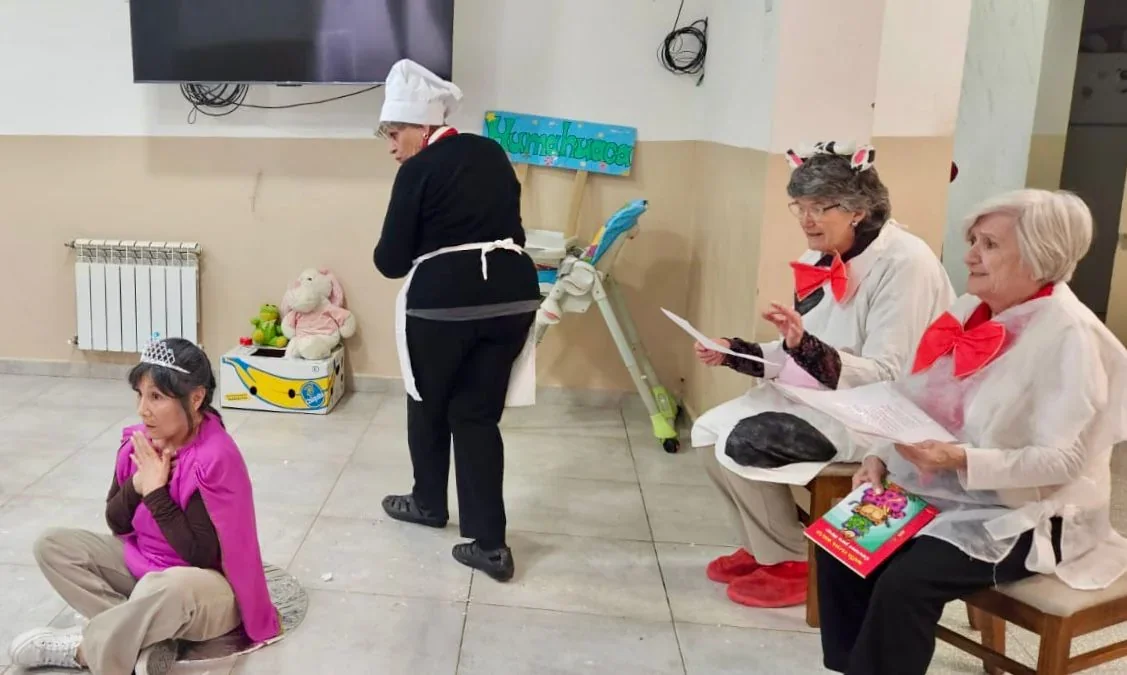 Mujeres del grupo Abuelas Lee Cuentos disfrazadas realizando una actividad teatral para niños en Puerto Madryn.