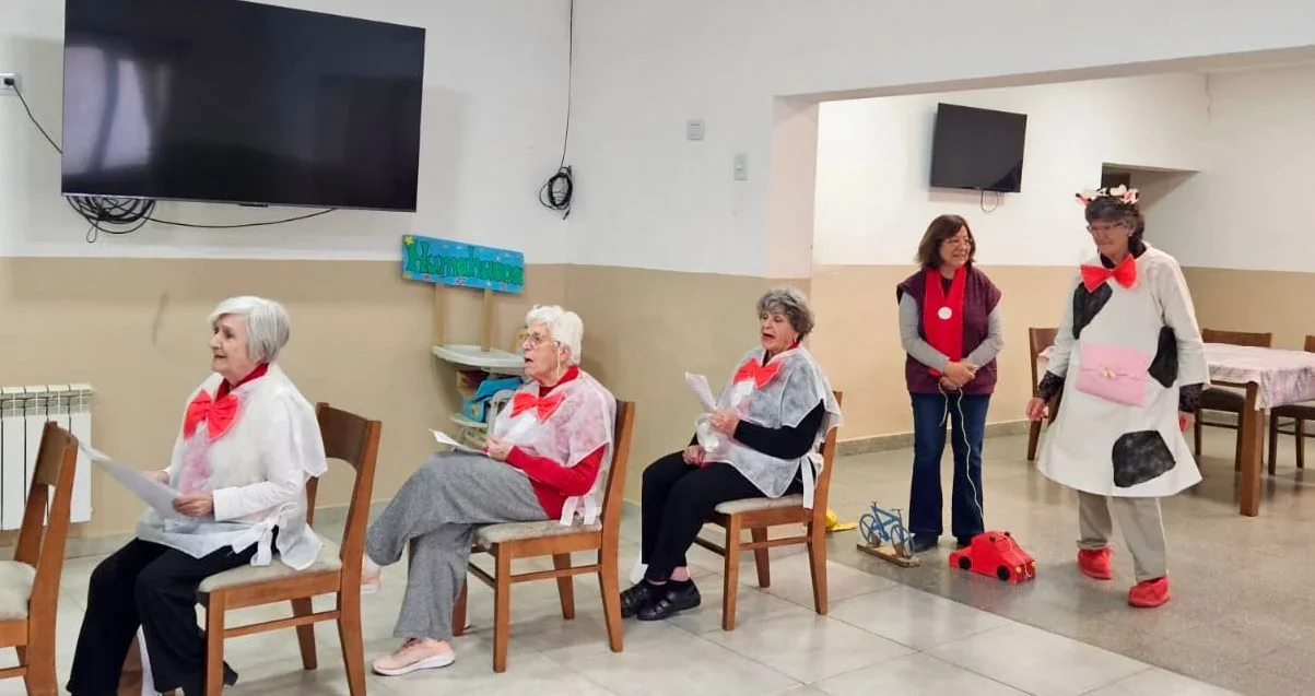 Mujeres del grupo Abuelas Lee Cuentos con disfraces y papeles en mano durante la jornada en el Centro Integral de la Niñez.