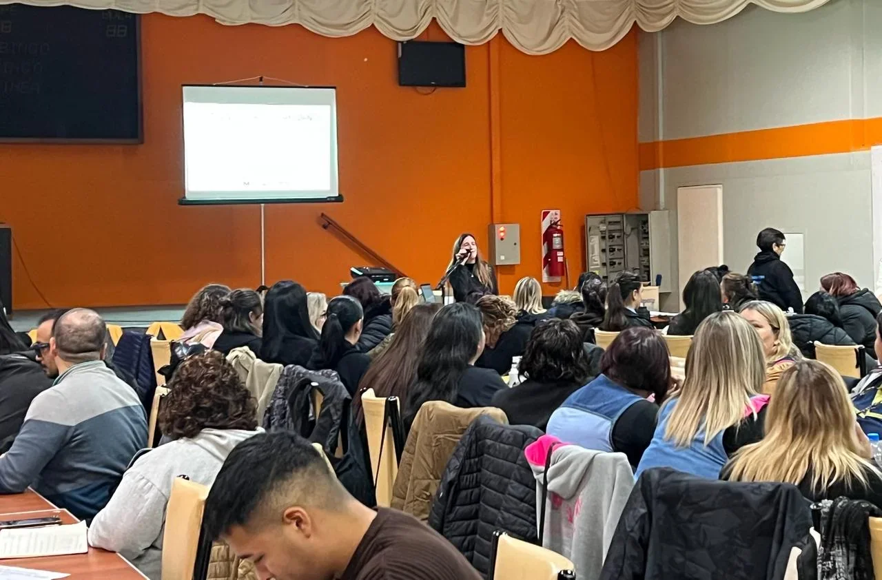 Agentes municipales de Puerto Madryn asistiendo a una capacitación sobre accesibilidad en un salón con una expositora.