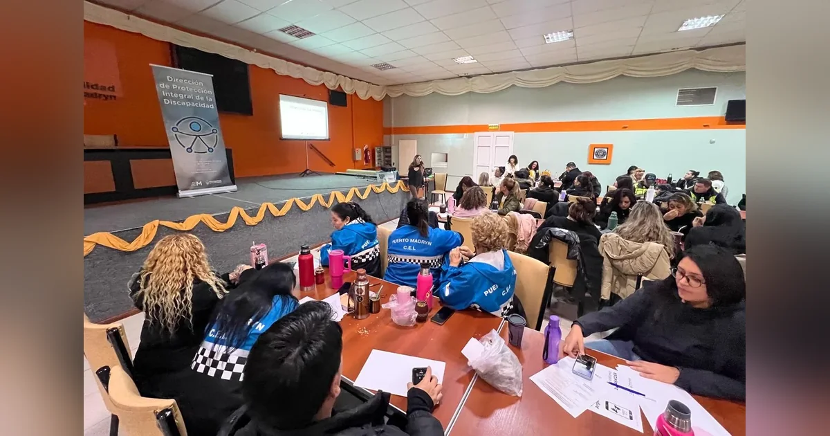 Puerto Madryn: más de 120 agentes se capacitaron en accesibilidad Agentes municipales de Puerto Madryn en una capacitación sobre accesibilidad en un salón con una pantalla proyectada.